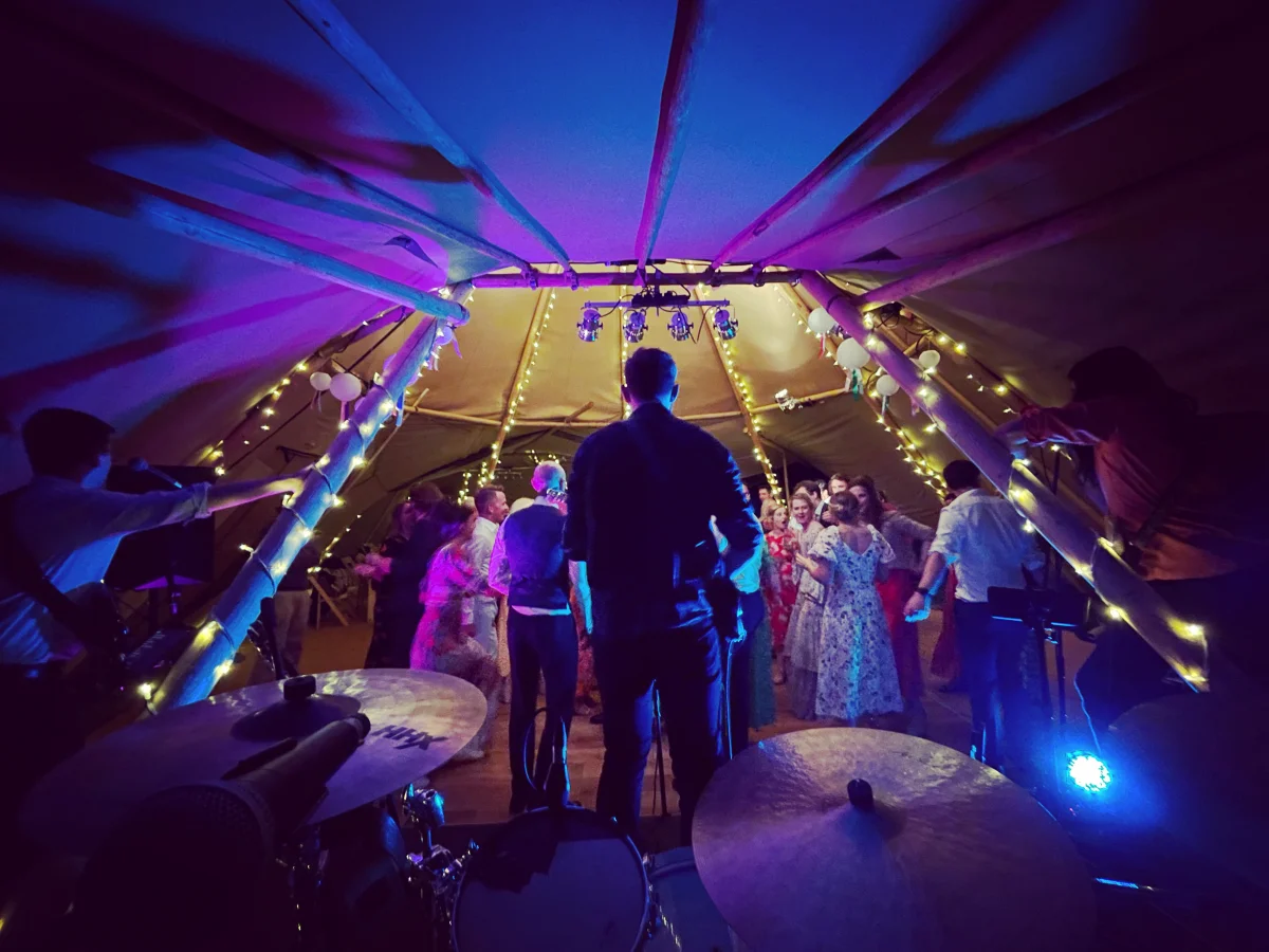 Kinmara performing inside a tipi wedding venue with fairy lights