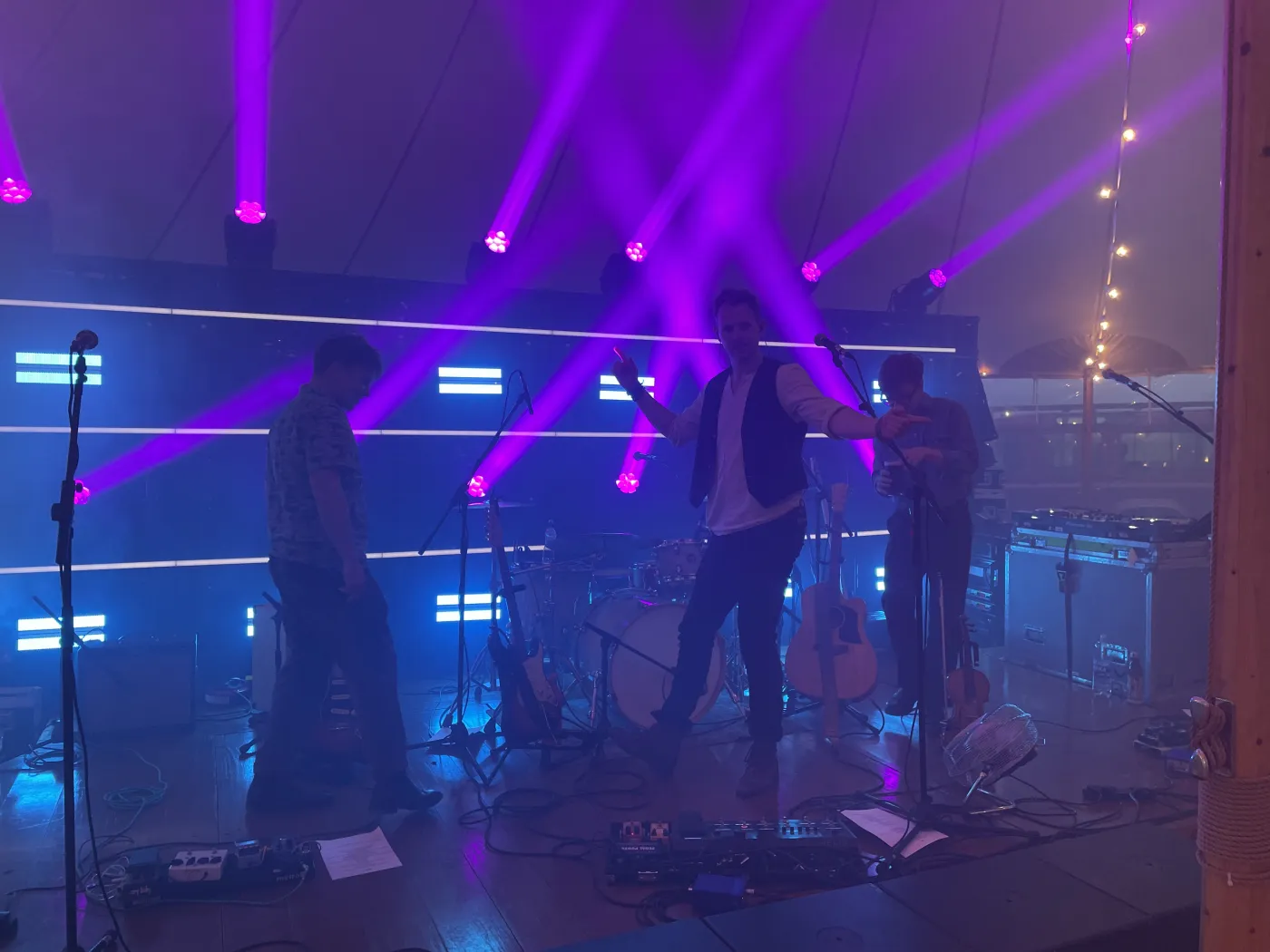 The full band on stage under dramatic purple lighting at an evening reception