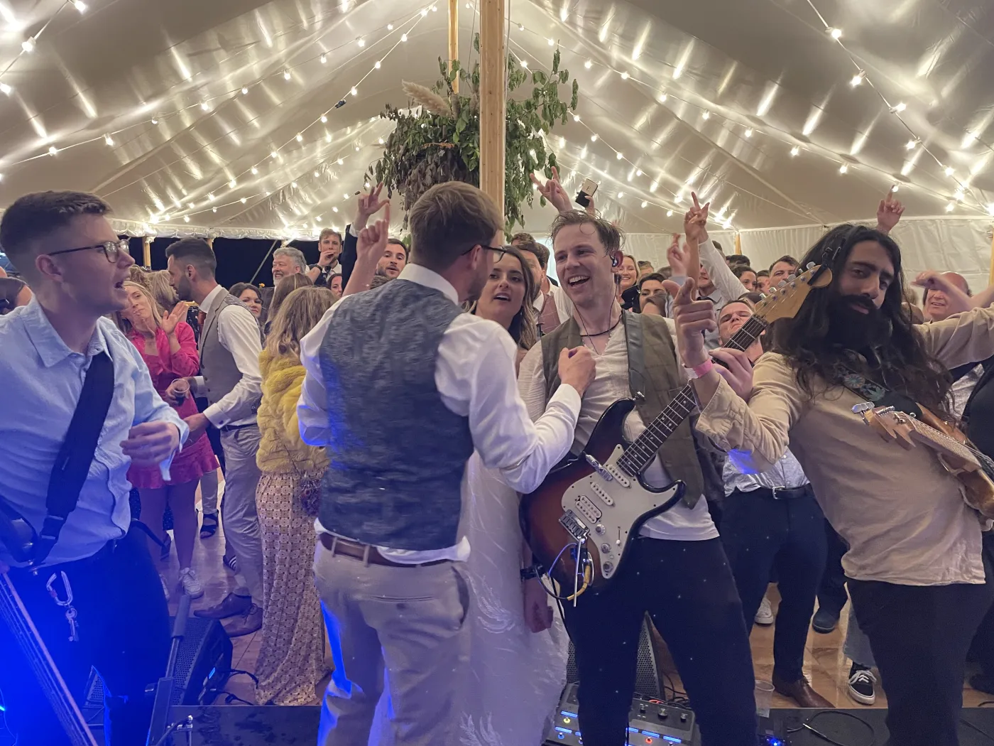 Kinmara playing to a packed, fairy-lit marquee dancefloor as the bride and groom dance at the front