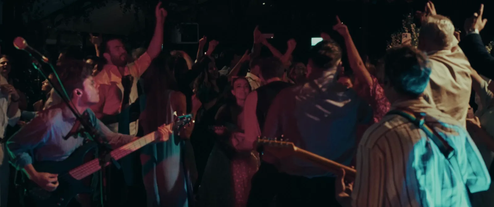Later in the same night from the stage camera: a full dancefloor, hands in the air, lit in blue and green